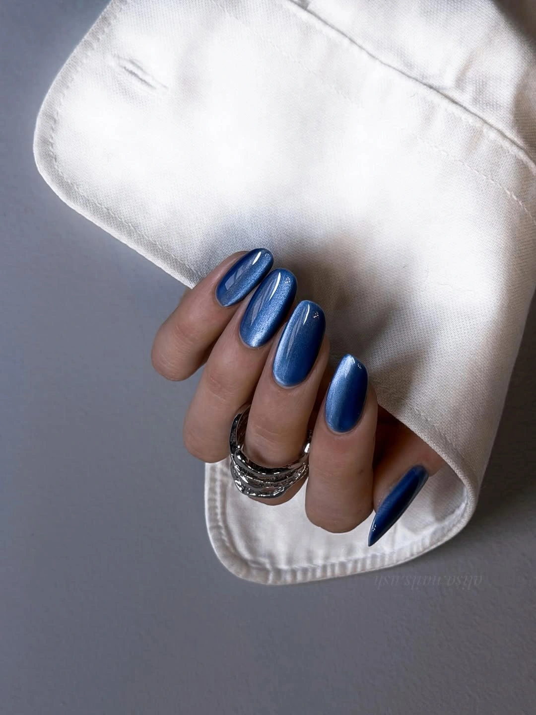 Long almond nails painted in glossy cobalt blue