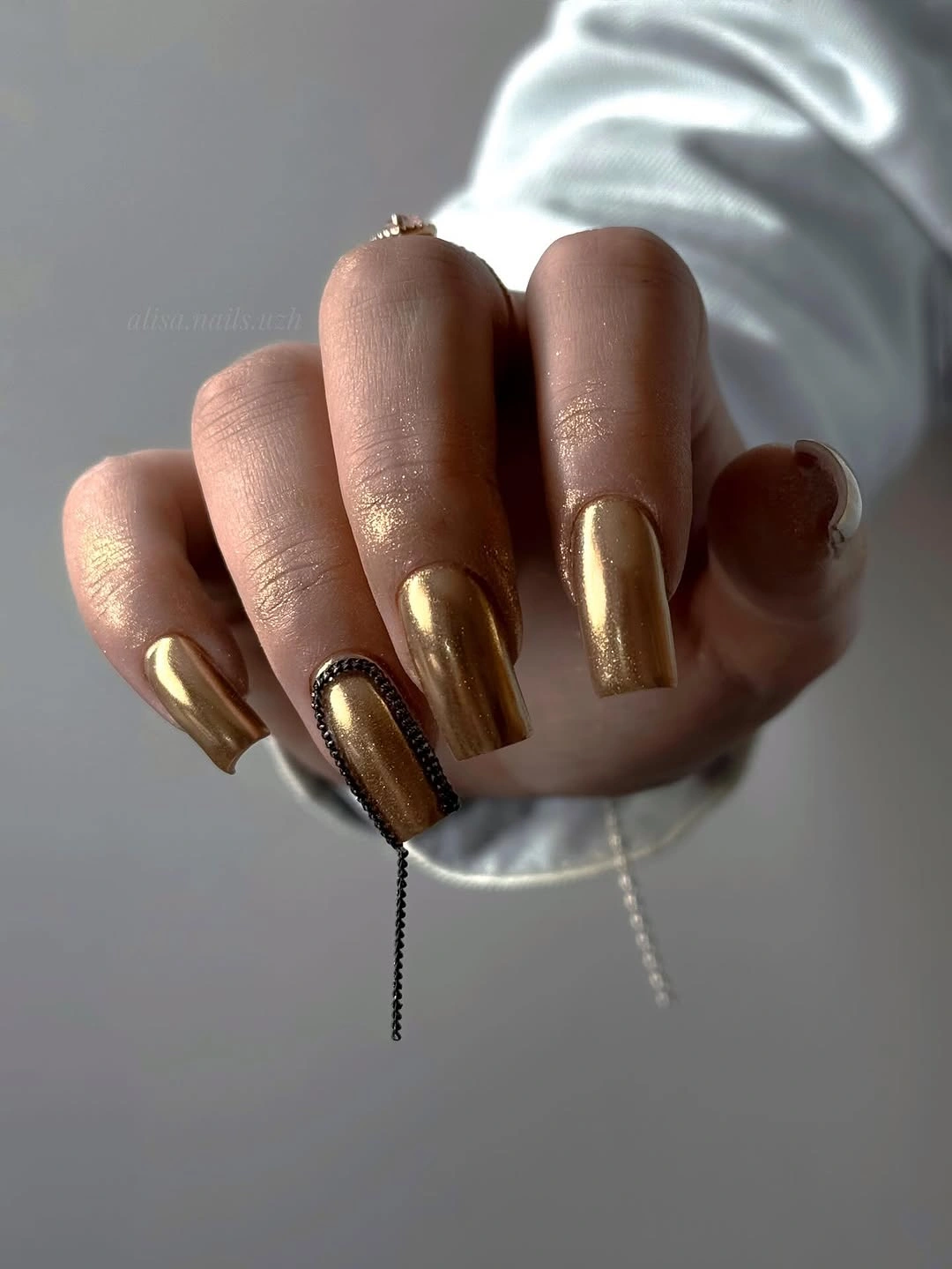 Long almond nails in reflective metallic gold