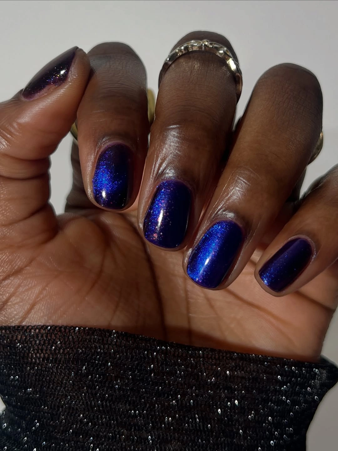 Short deep blue nails with fine reflective shimmer