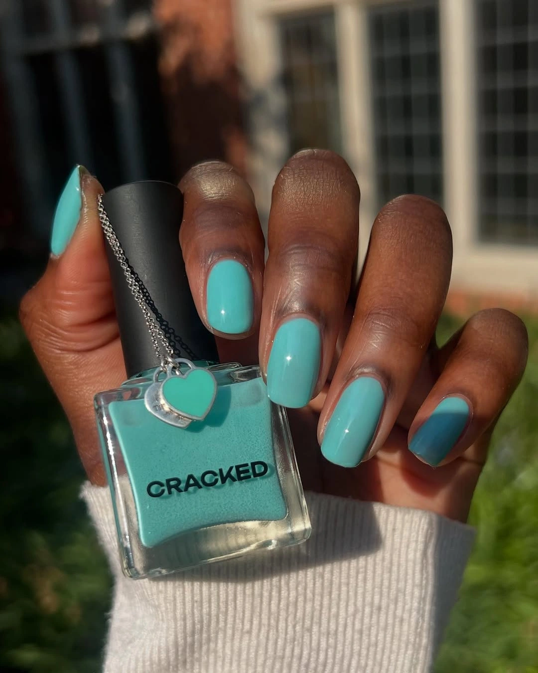Bright turquoise medium square nails with a matching color prop