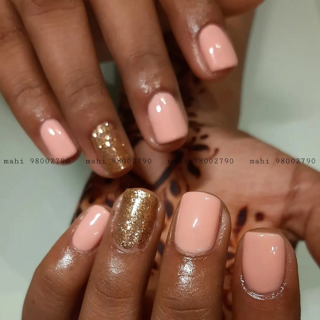 Short blush square nails with one gold glitter accent