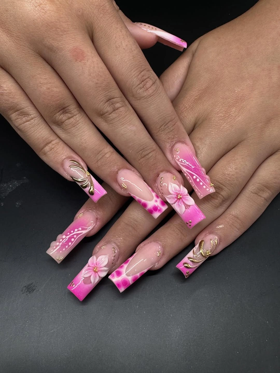 Long pink square nails with white flowers and gold accents