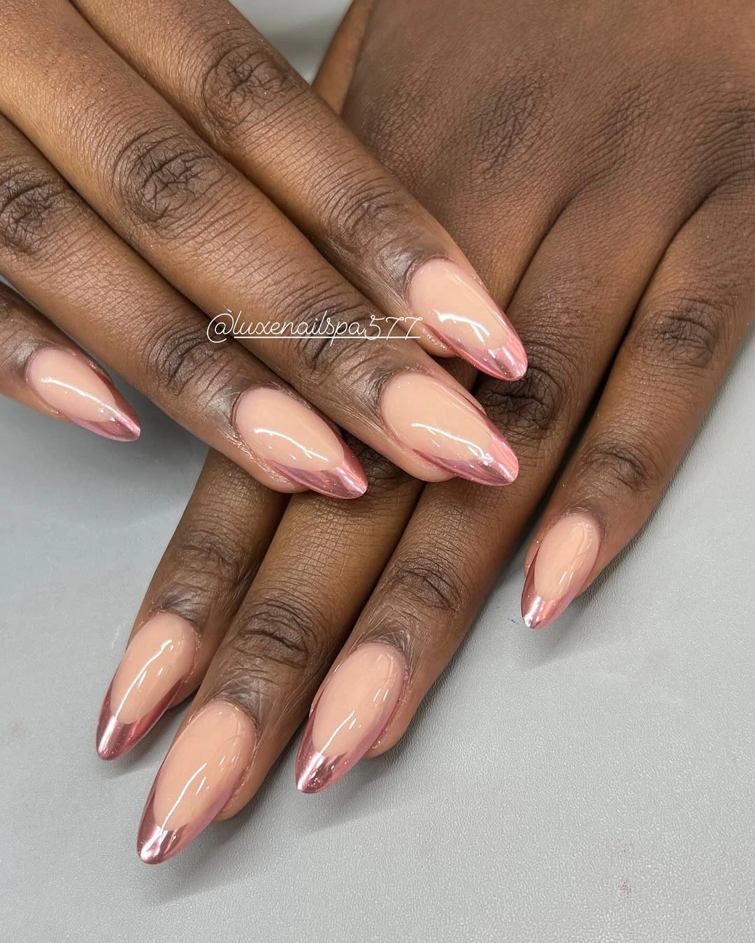 Nude almond nails with narrow rose metallic tips