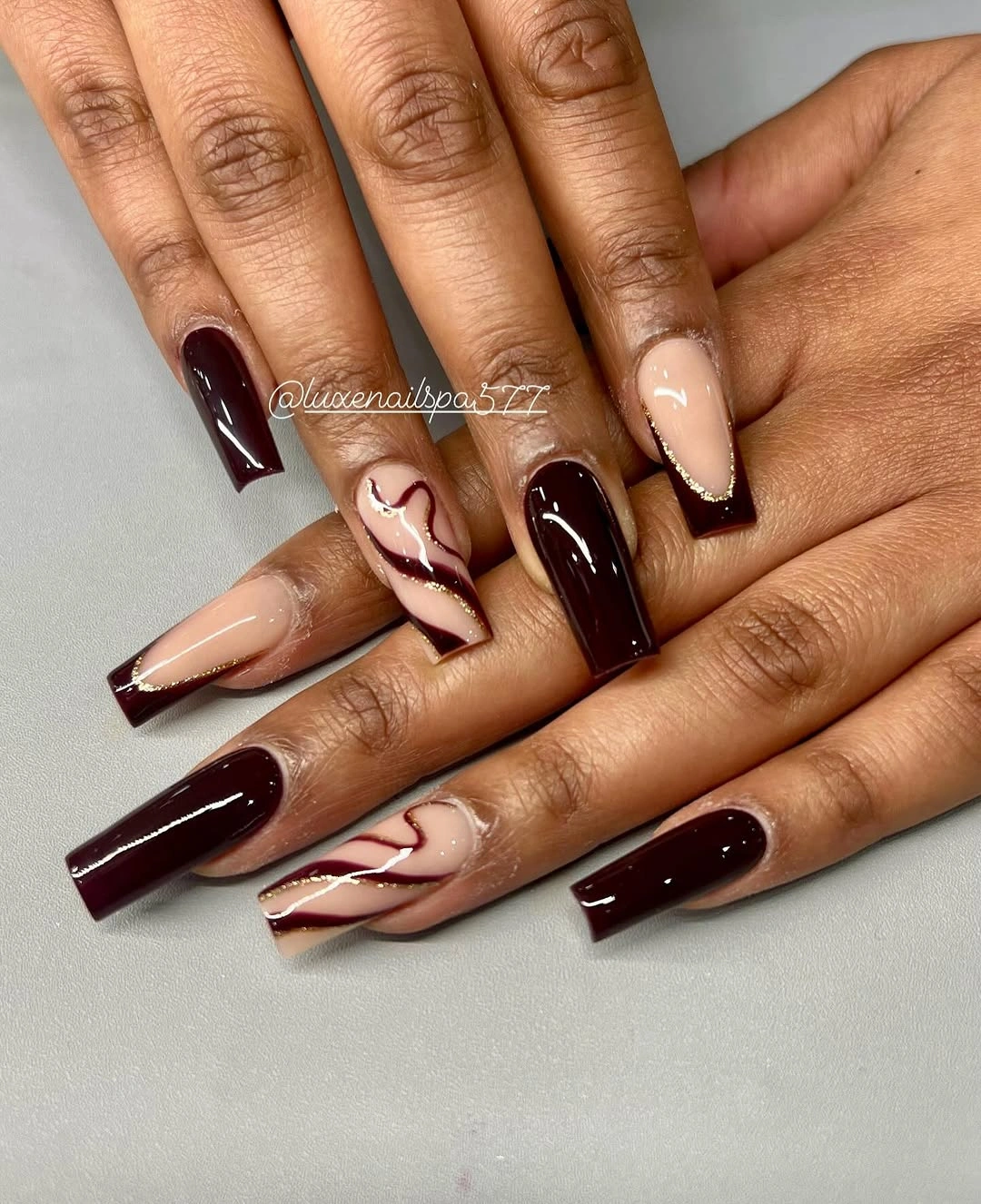 Deep burgundy square nails with nude wavy accents