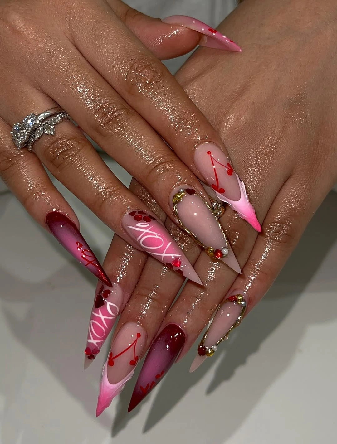 Long stiletto nails with burgundy hearts and gold frames