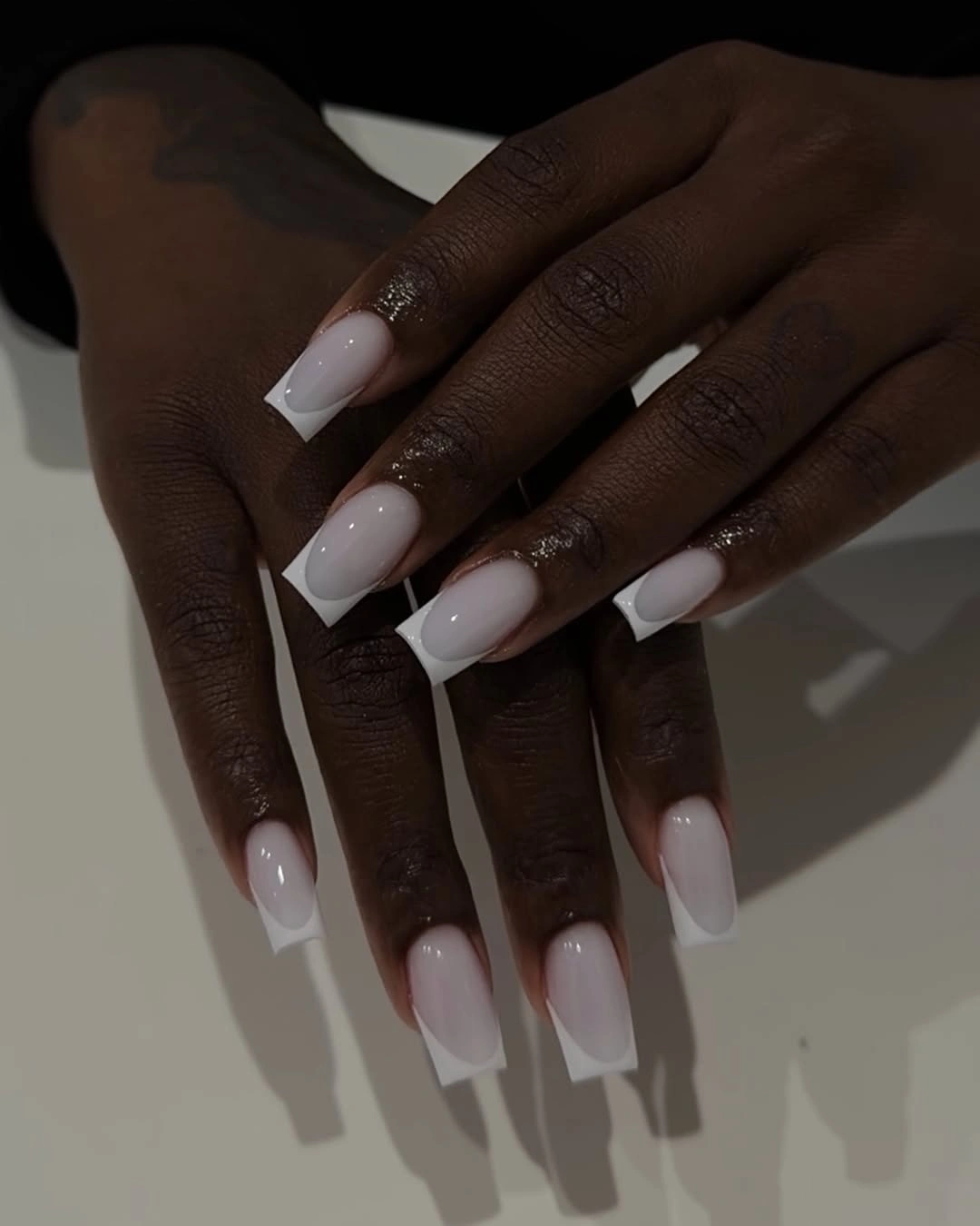 High-contrast square French tips on deep skin