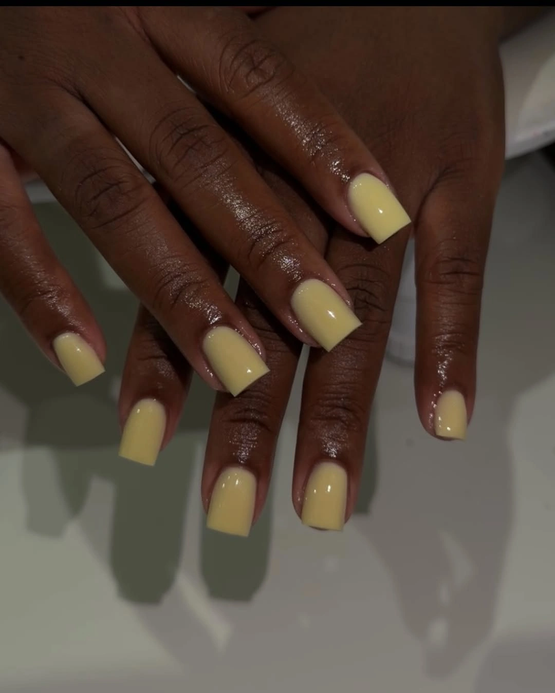 Short square nails with creamy yellow polish