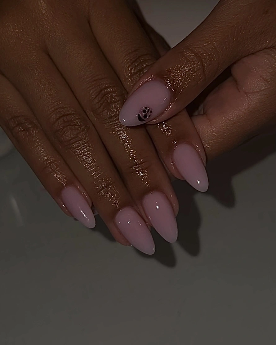 Pale almond nails with one tiny black accent