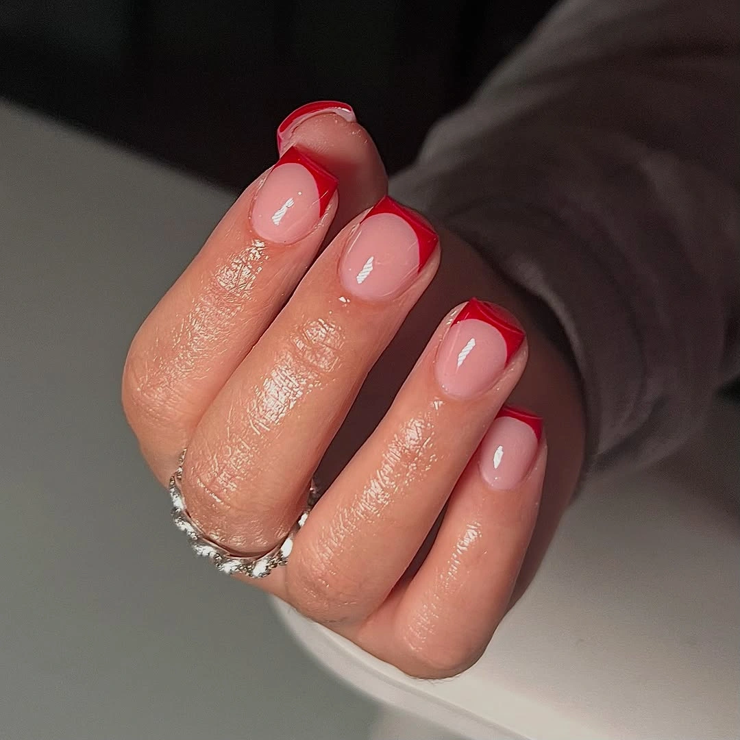 Short nude nails with glossy red French tips
