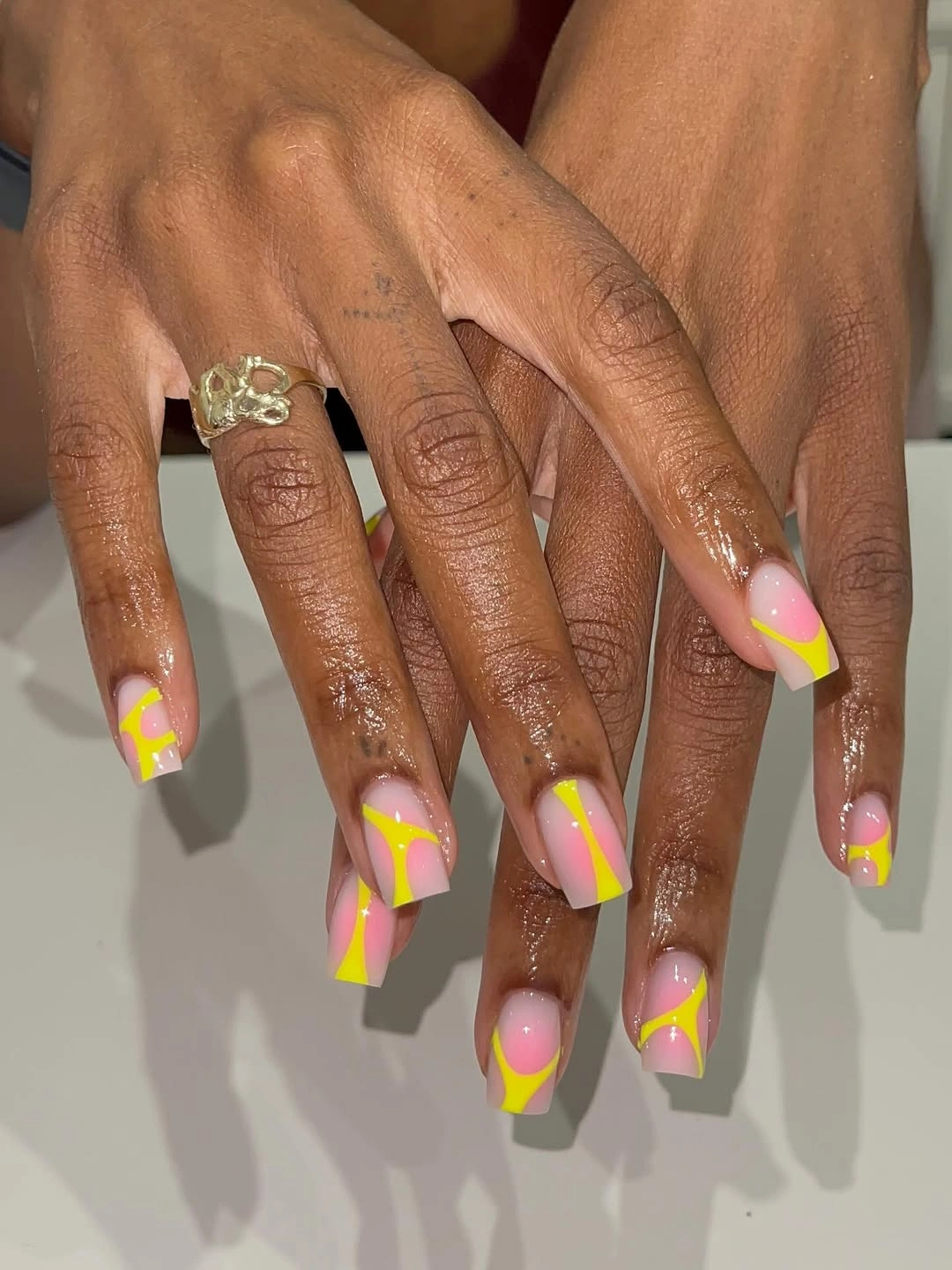 Nude square nails with neon yellow curved accents