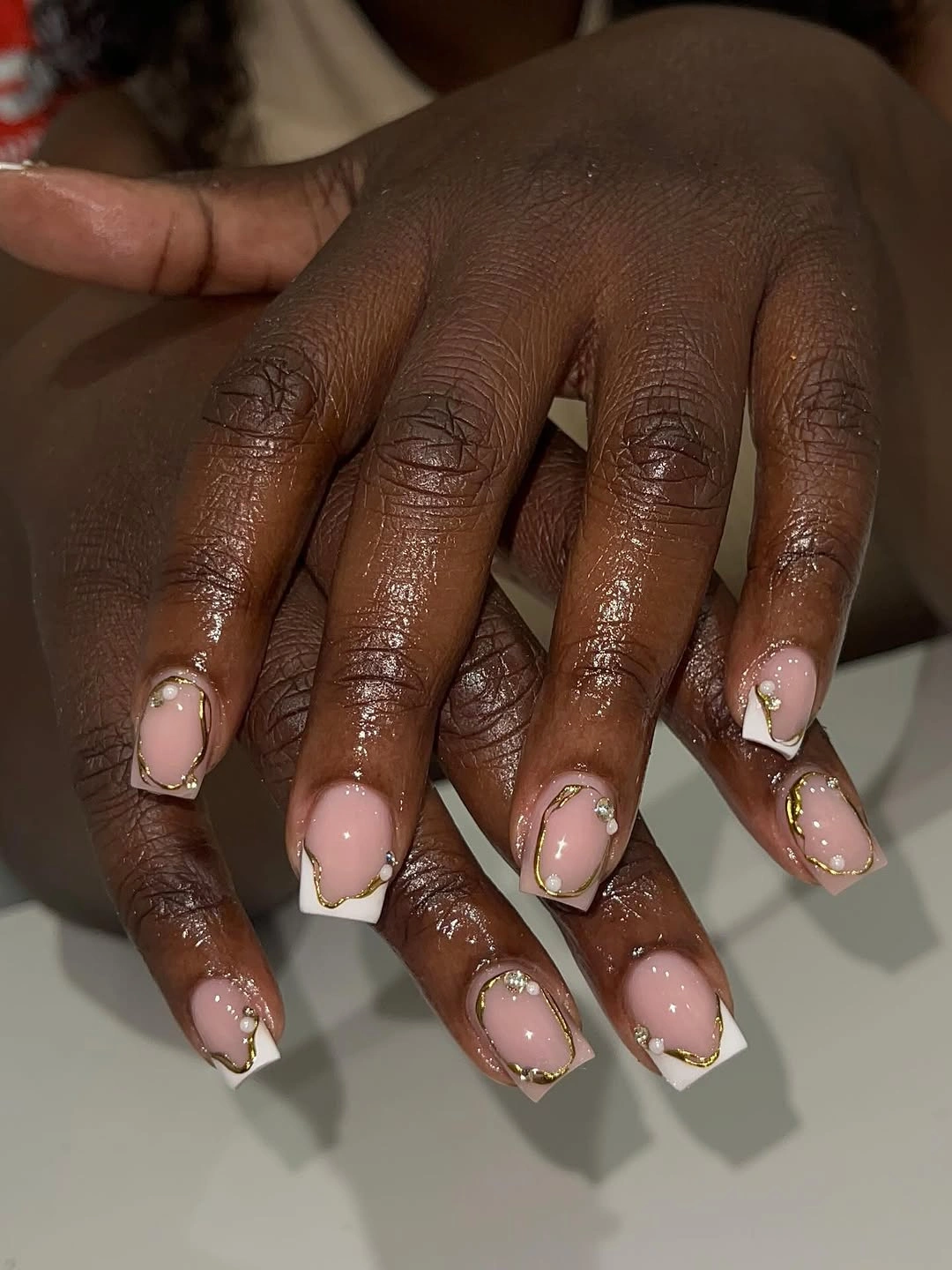 Gold-framed French nails with pearl-like accents