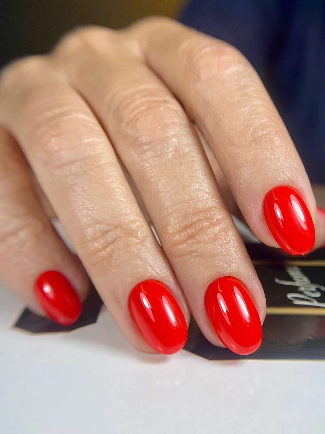 Short oval nails in glossy vivid red