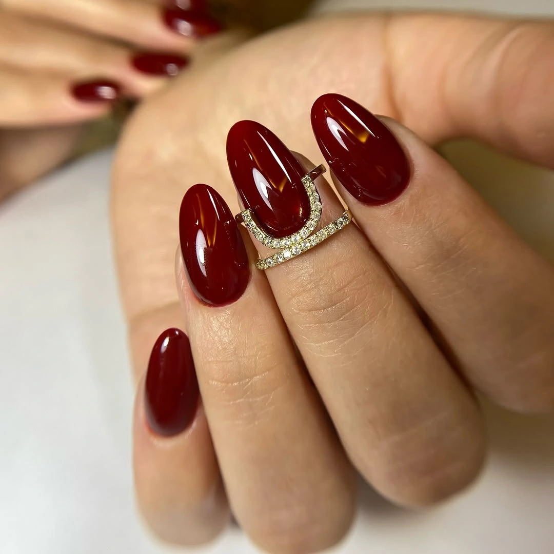 Short almond burgundy nails with one silver line accent