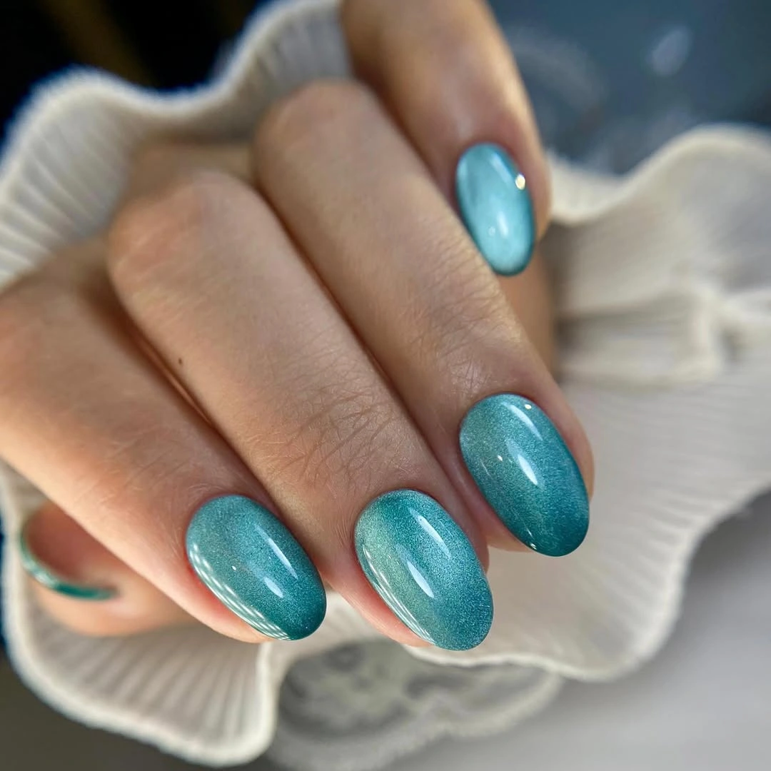 Short rounded aqua blue nails with fine surface sparkle