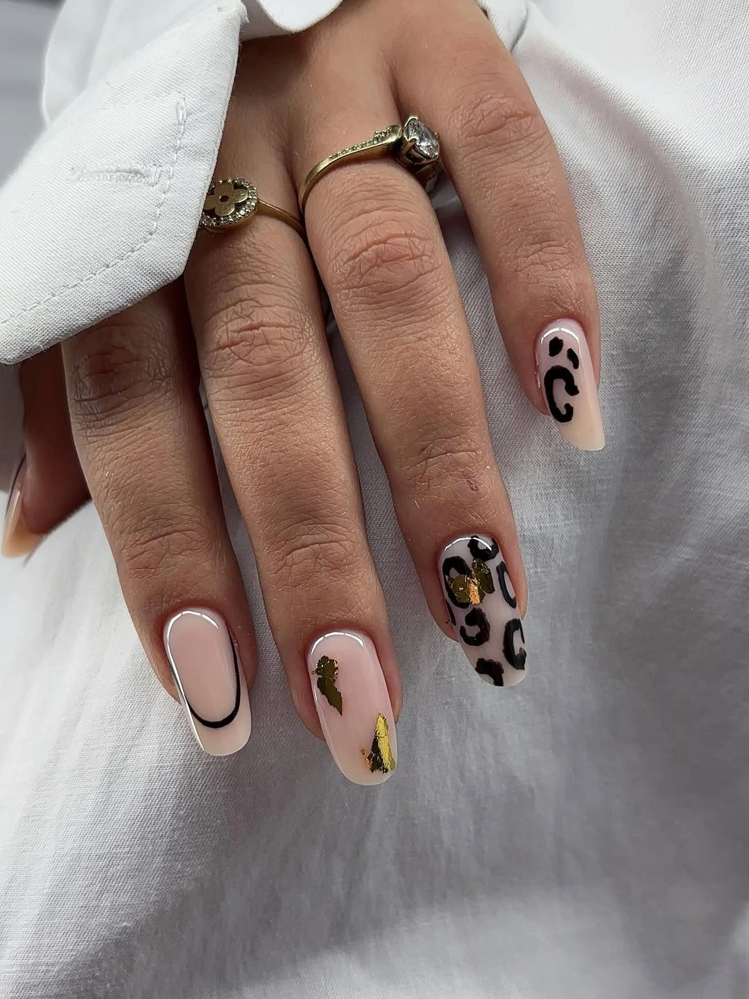 Short creamy nails with irregular dark spotted accents