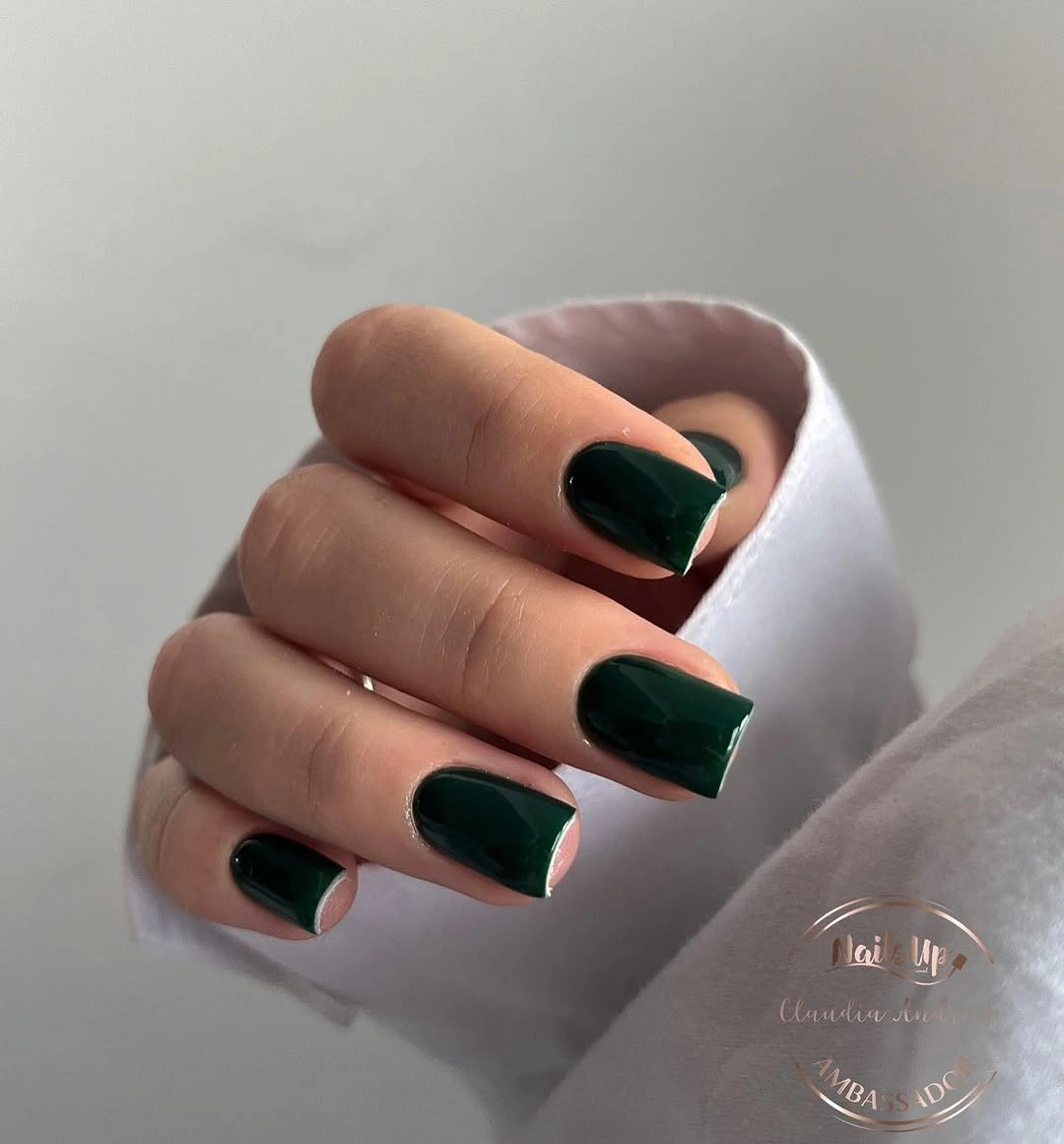 Short glossy forest green nails on a compact square shape