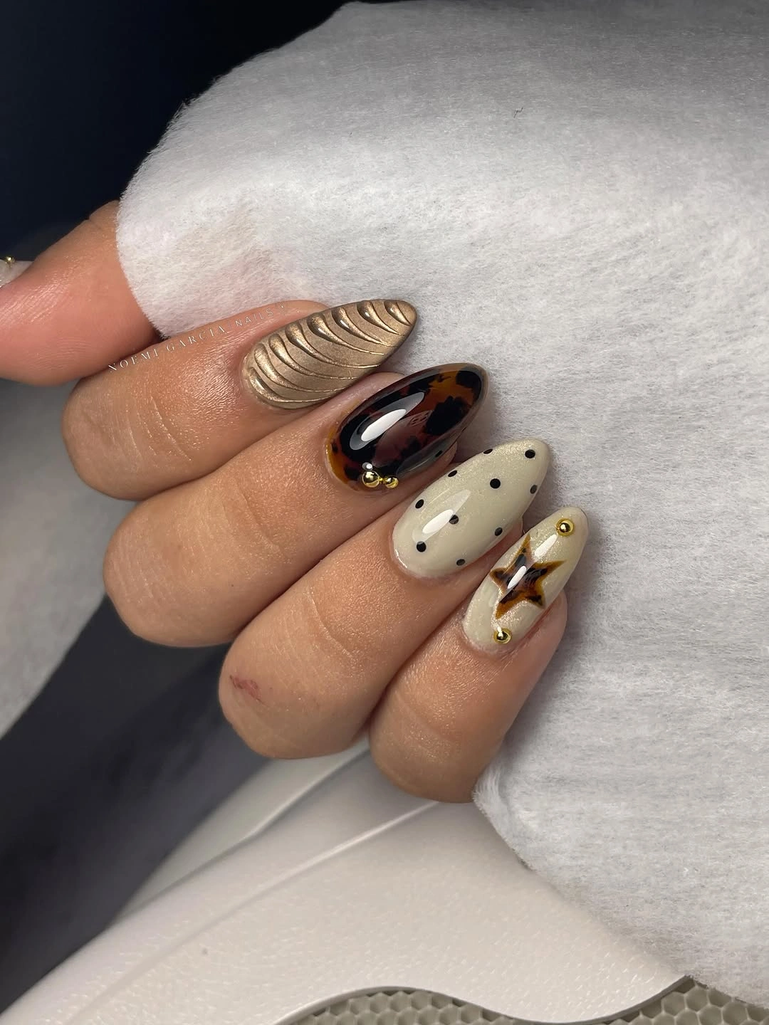 Long almond nails with earthy spots gold and dark accents