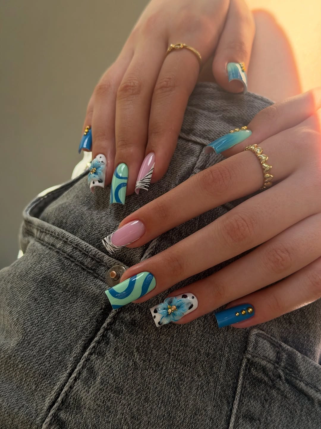 Long pale nails with blue green and colorful accents