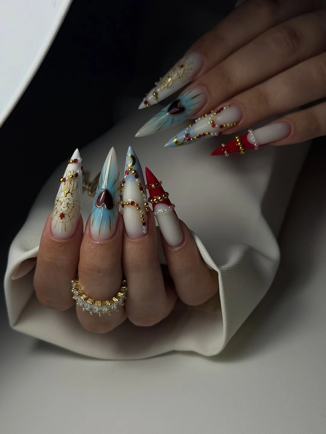 Very long pointed nails with ornate multicolor accents