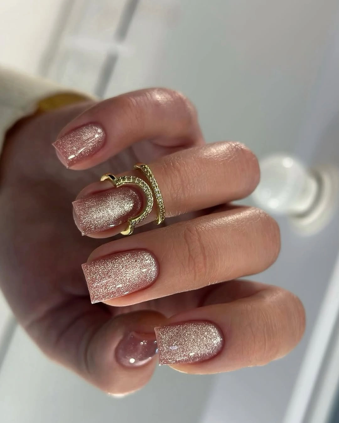 Rose-gold shimmer nails on a medium rounded square