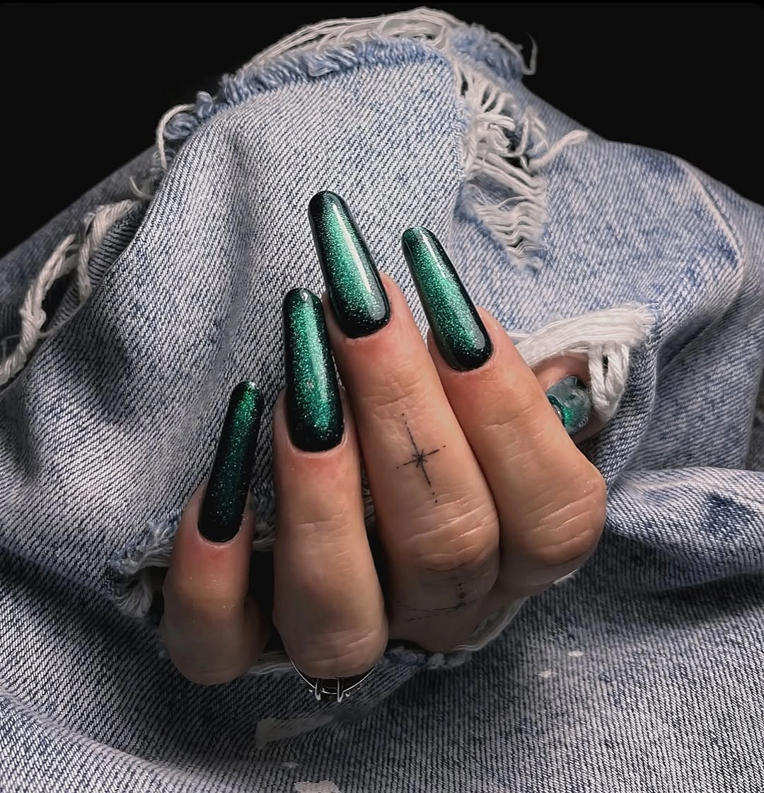 Very long pointed nails in reflective emerald green