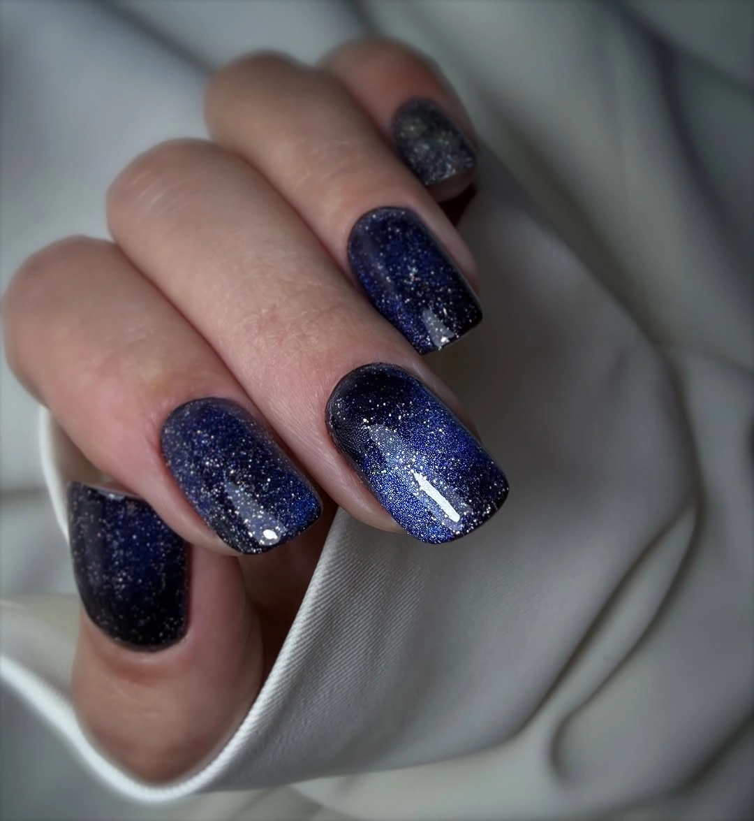 Short square navy nails with fine silver blue sparkle
