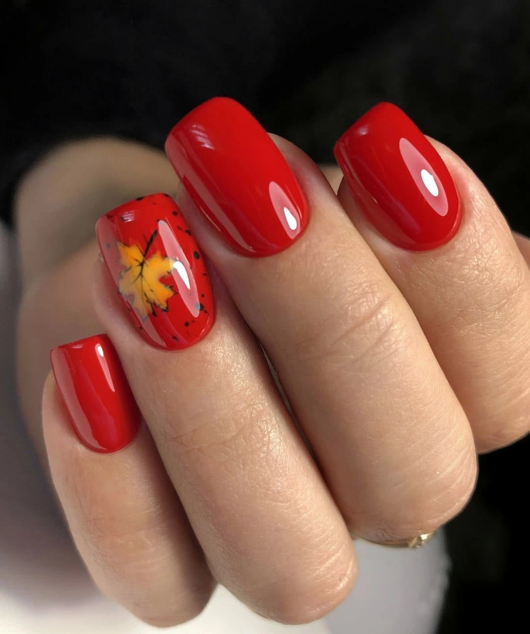 Glossy red square nails with one yellow floral accent