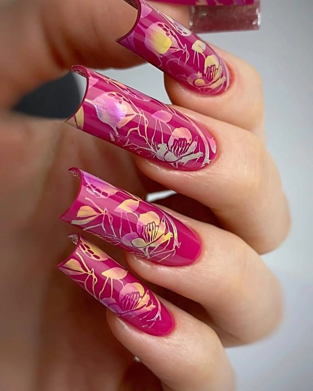 Long magenta nails with pale botanical linework
