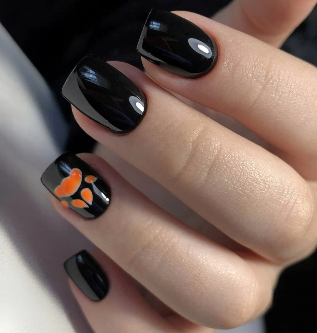 Glossy black square nails with one orange accent
