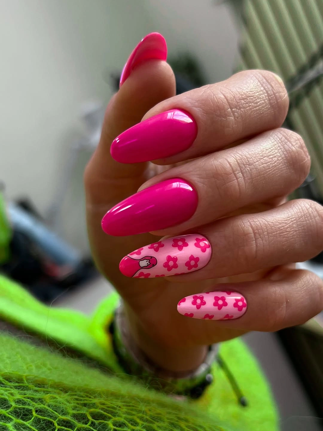 Hot pink almond nails with two pale patterned accents