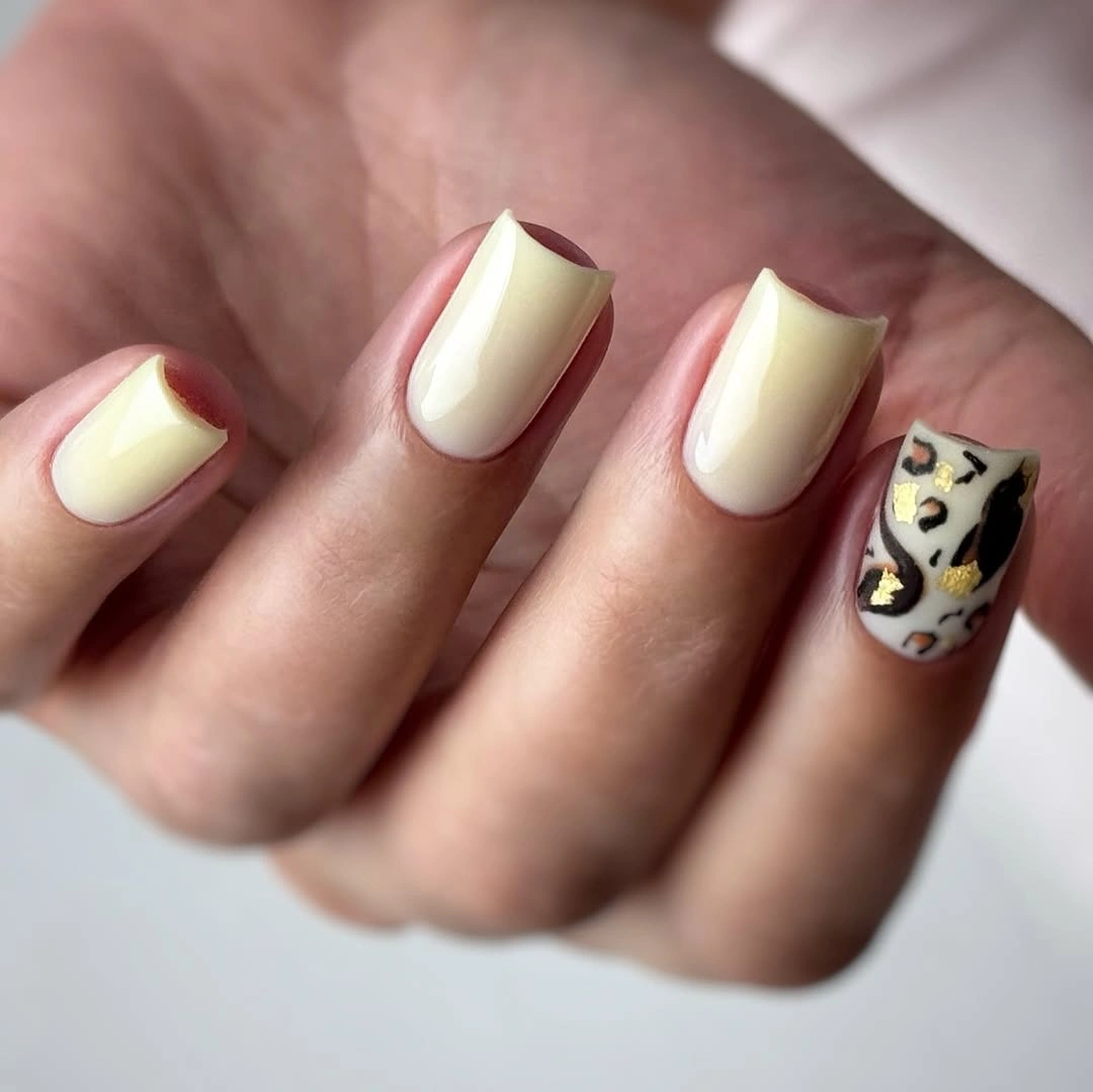 Medium ivory square nails with one brown and mustard patterned accent