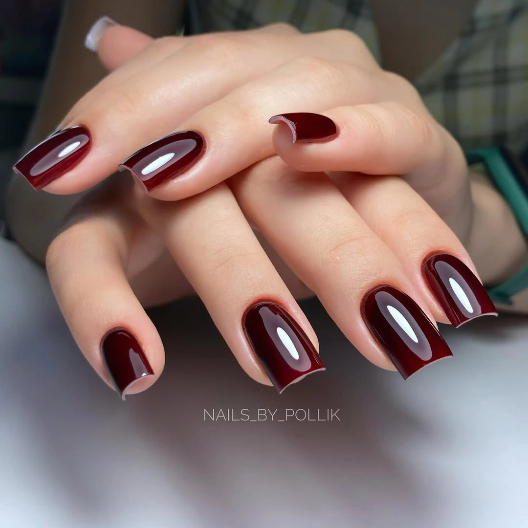 Medium square burgundy nails with pale glossy central highlights