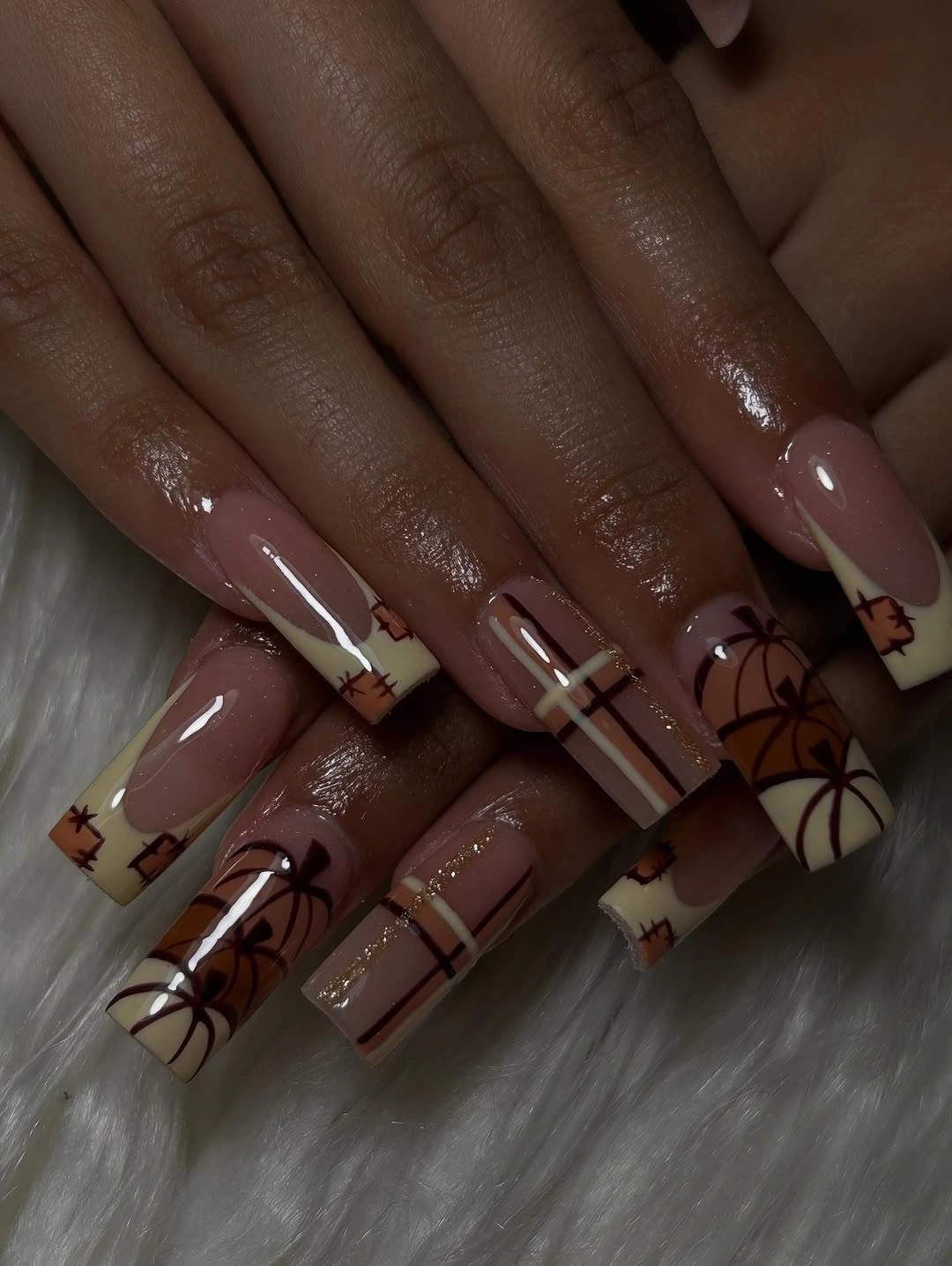 Medium almond taupe nails with subtle black and orange pumpkin drawings