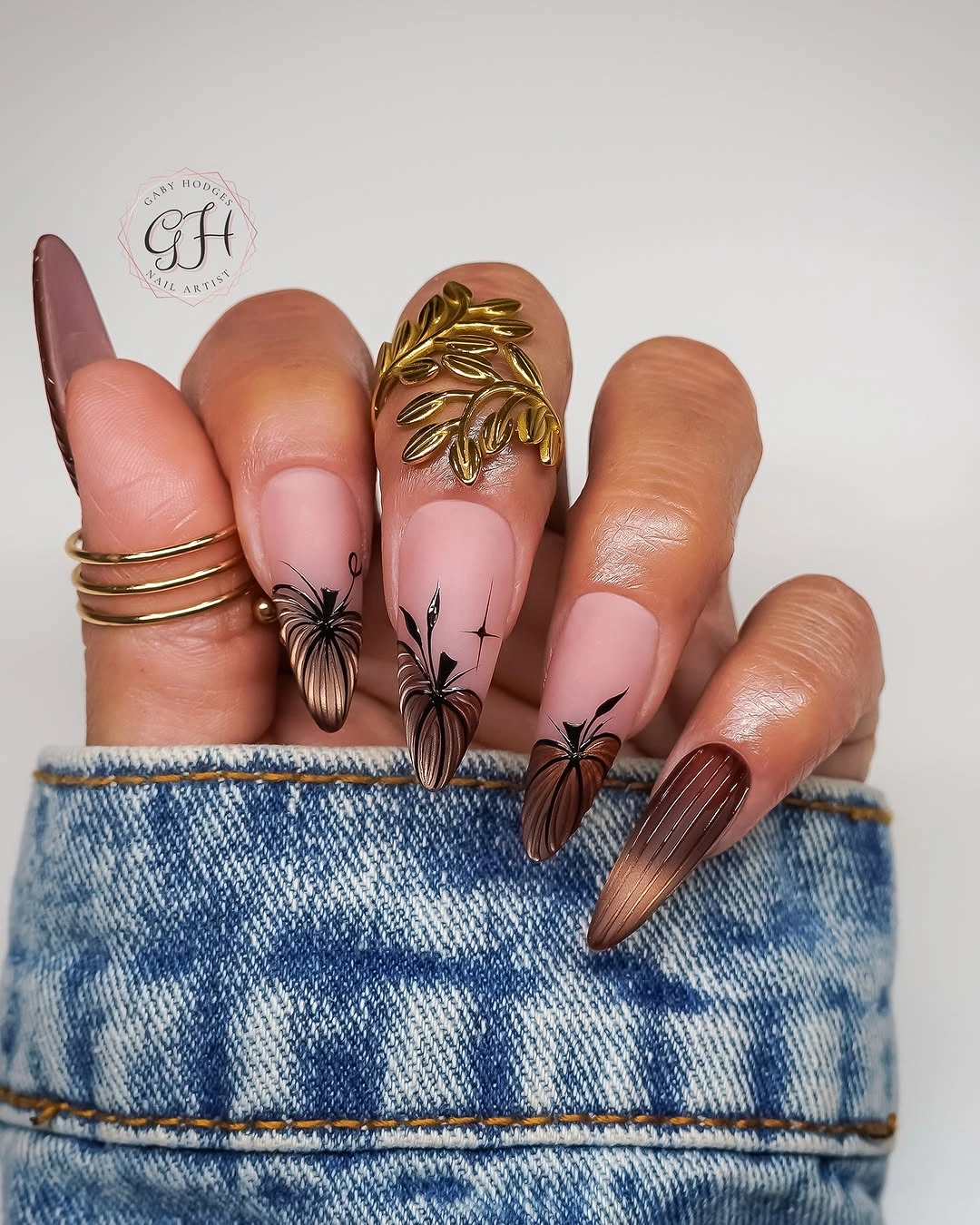 Long pointed pink nails with curved white tips and autumn leaf details