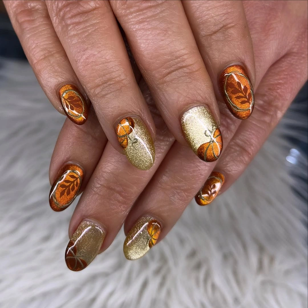 Medium almond brown amber nails with glossy pumpkin and leaf accents