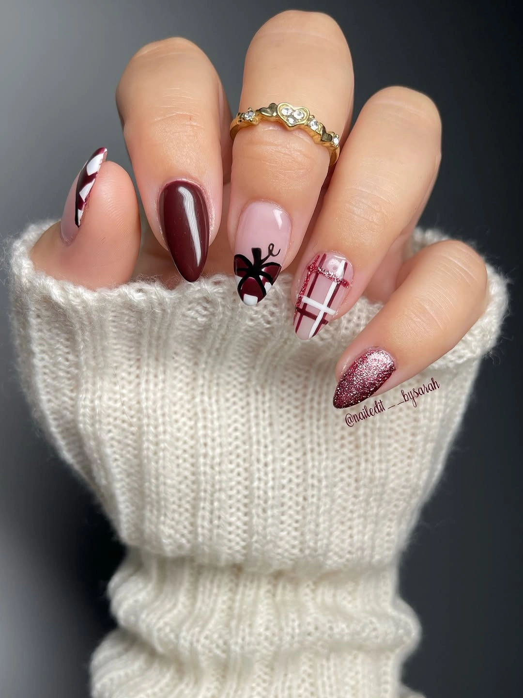 Medium almond burgundy nails with pale botanical and plaid accents