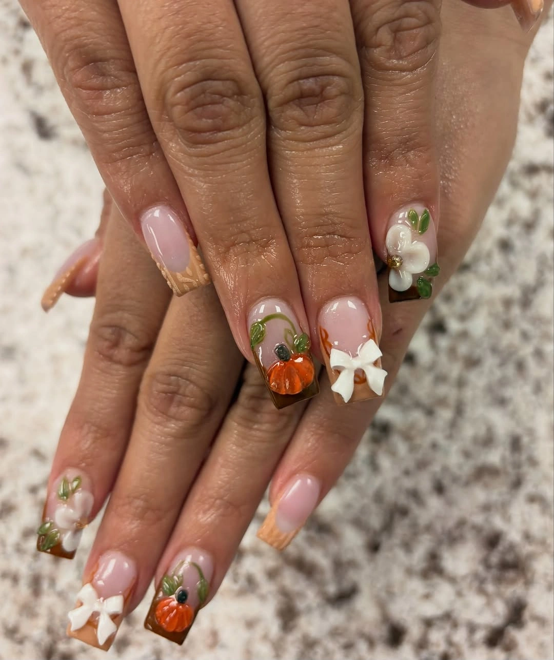 Medium almond pale pink nails with pumpkins bows and green leaves