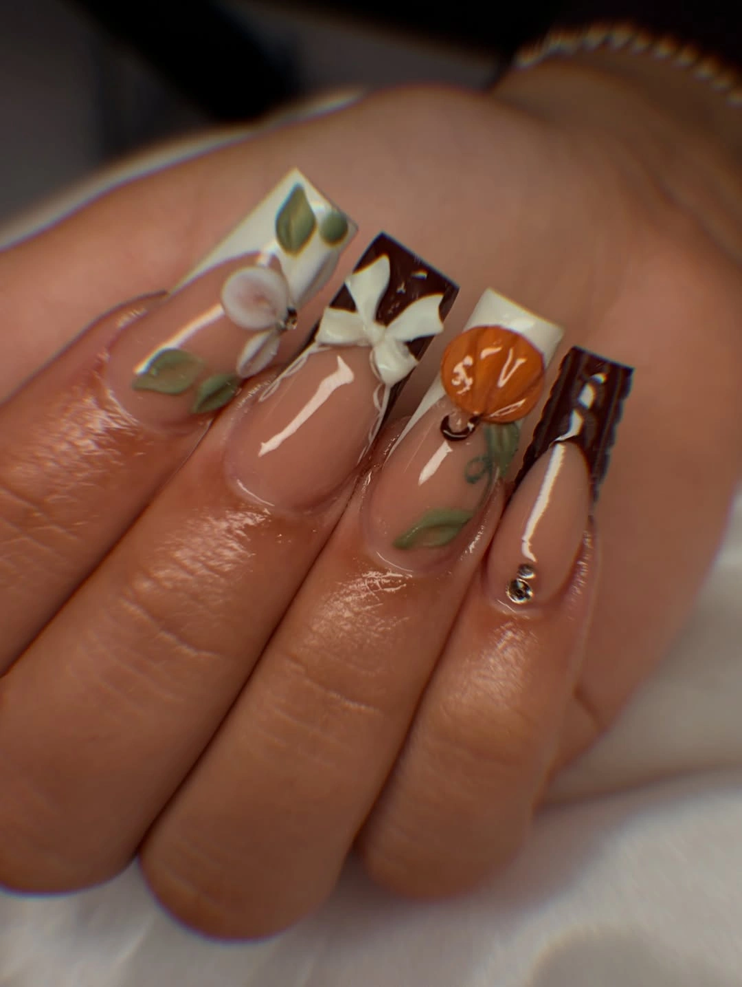 Long almond fall nails with earthy taupe green and checkerboard accents