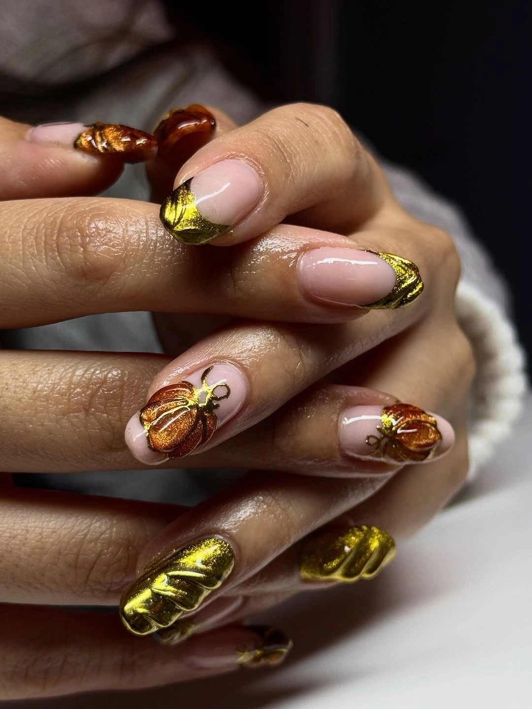 Long pointed nude nails with large glossy orange pumpkin artwork
