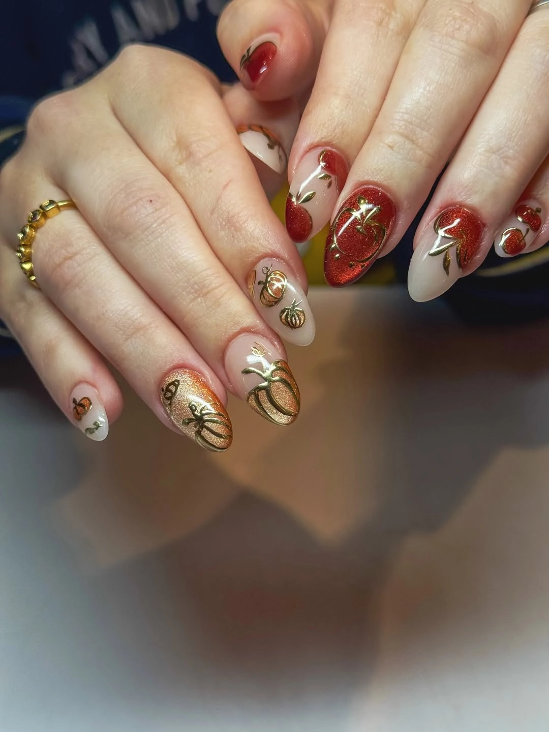 Medium almond red cream nails with delicate autumn botanical linework