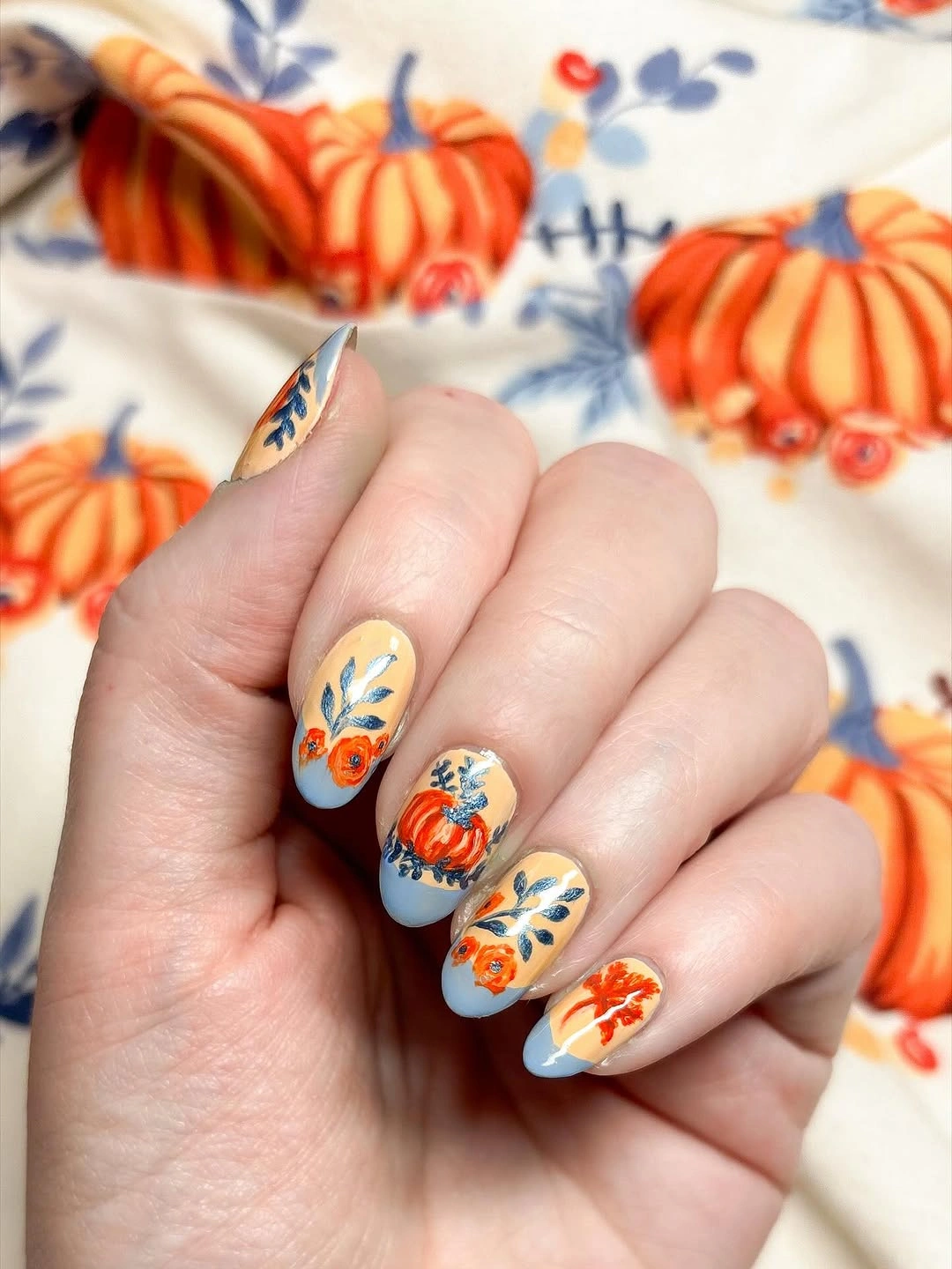 Short square pale blue nails with colorful pumpkin illustrations