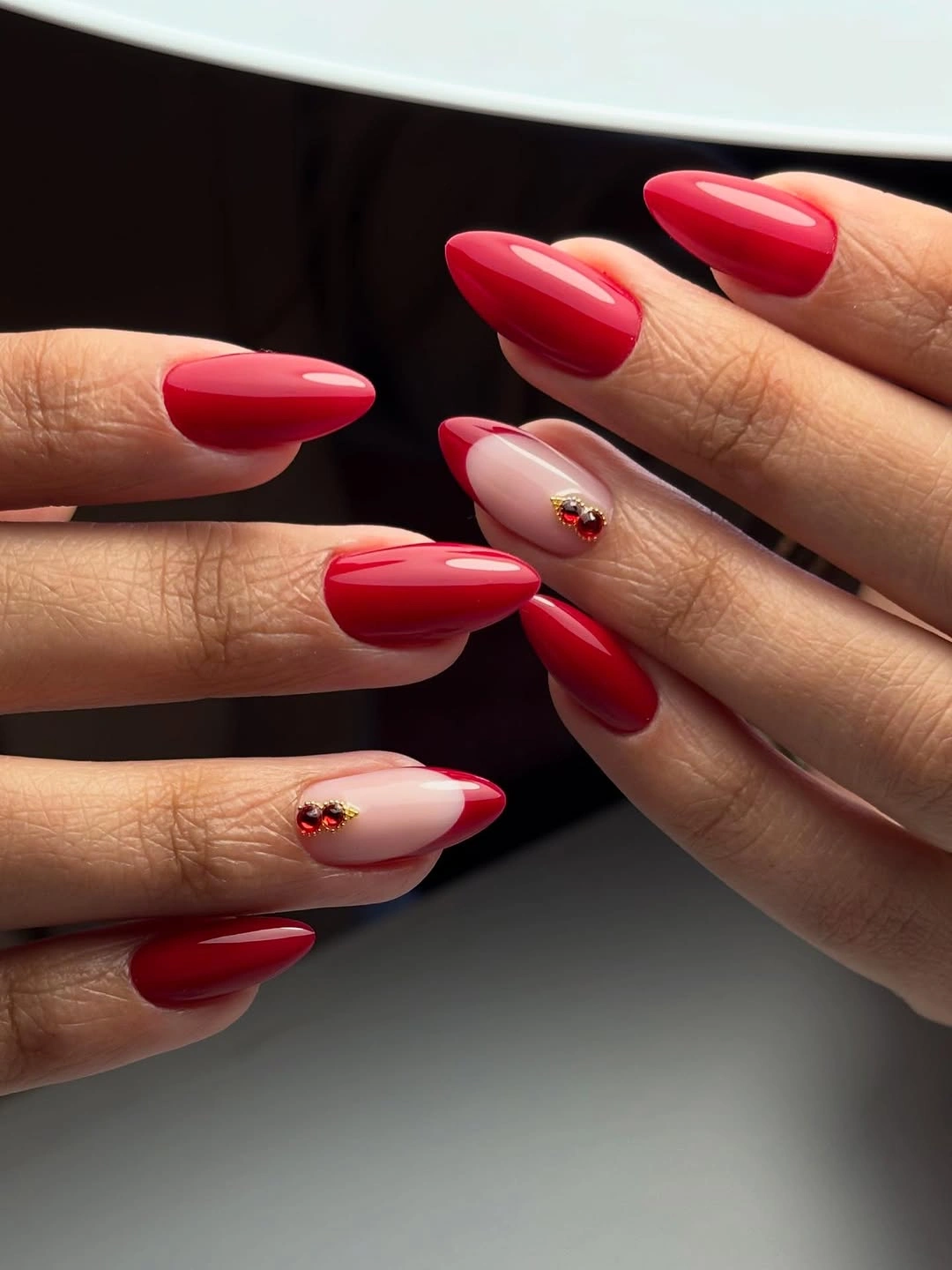 Red almond nails with tiny nude accents