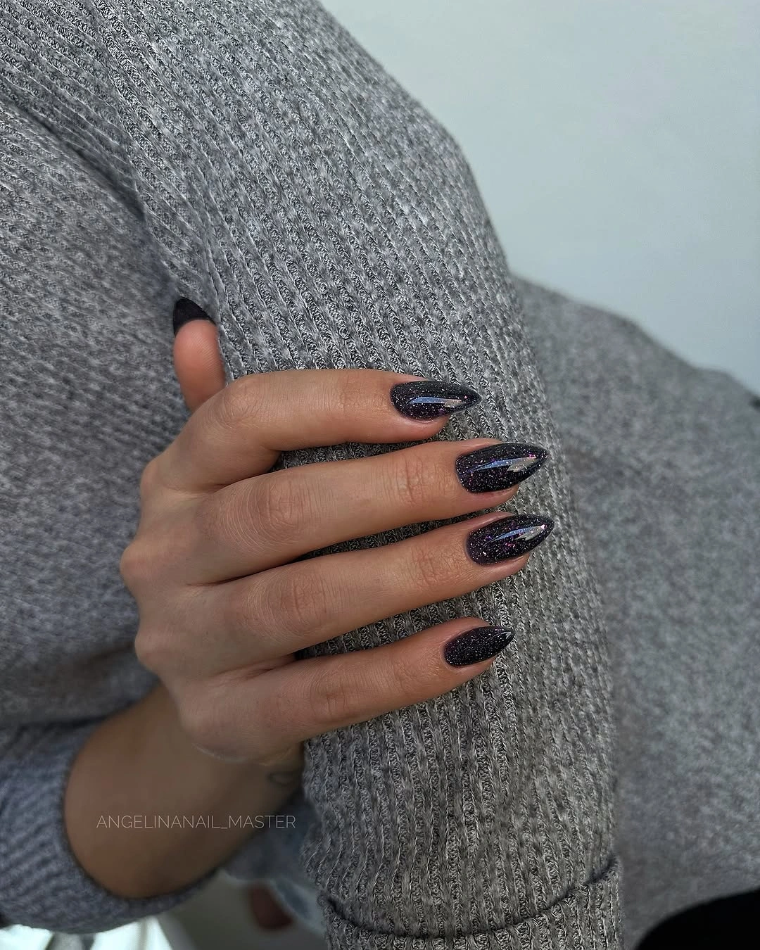 Dark charcoal almond nails with fine cool shimmer