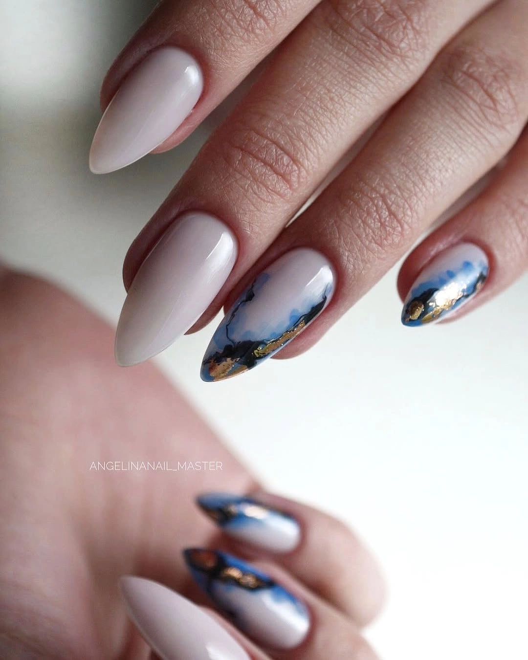 Milky almond nails with blue white painterly and gold accents
