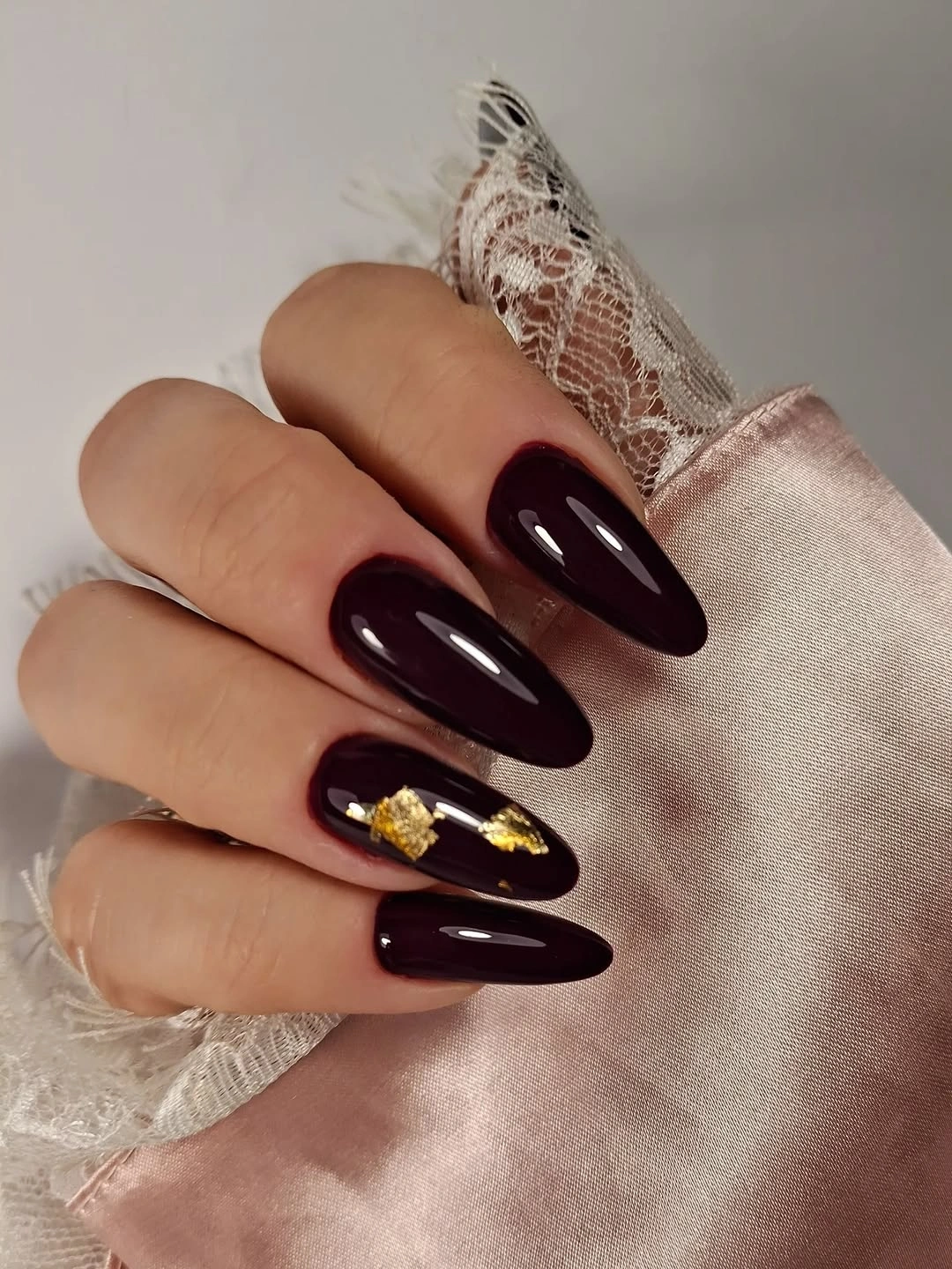 Long glossy deep plum almond nails with one gold accent