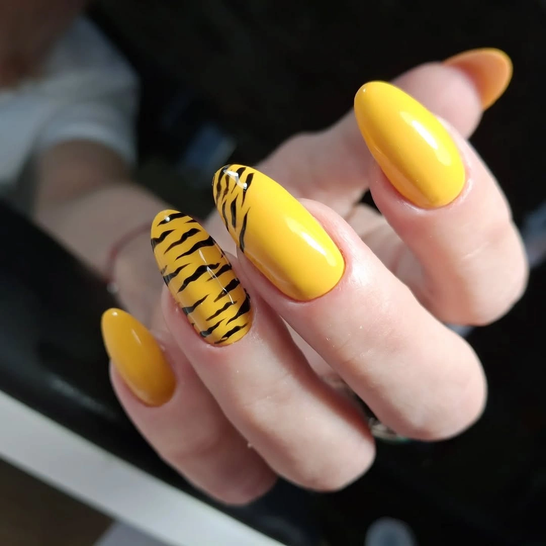 Long almond nails with sunny yellow and one black tiger stripe accent