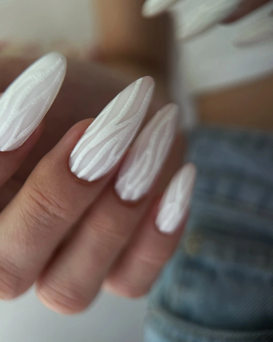 White almond nails with raised-looking lengthwise wavy lines