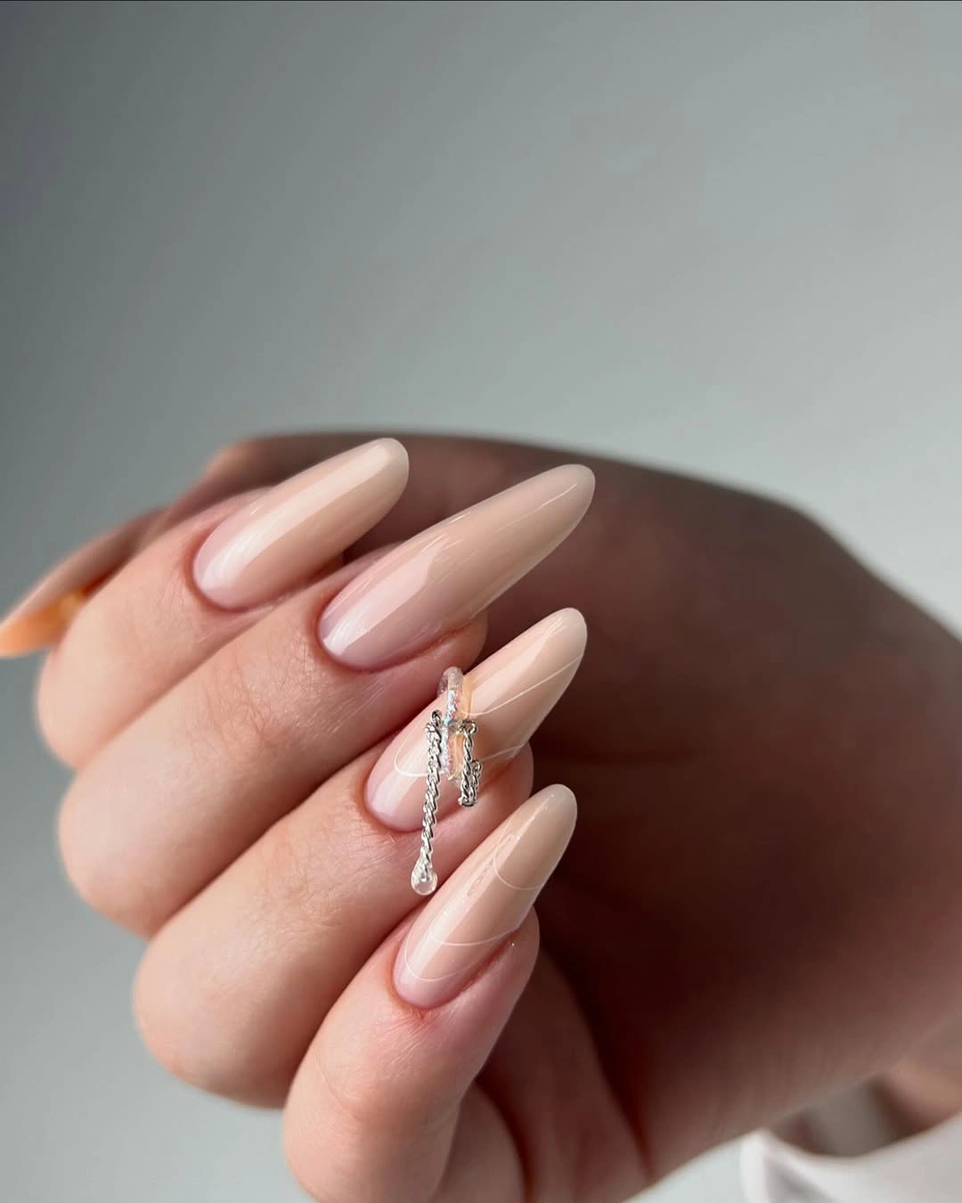 Long almond nails with sheer blush base and one delicate gold center accent