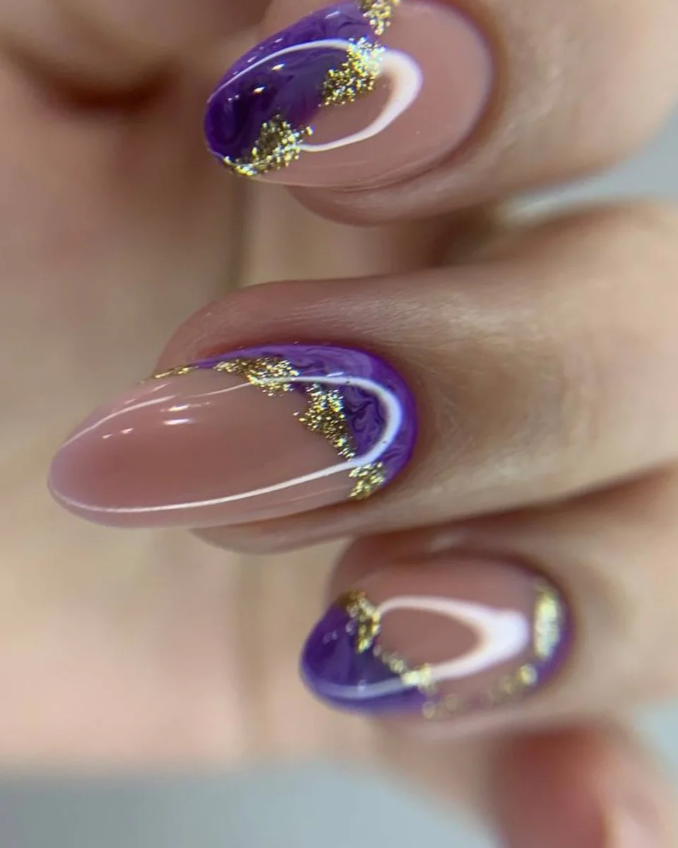 Nude almond nails with deep purple French curves and gold touches