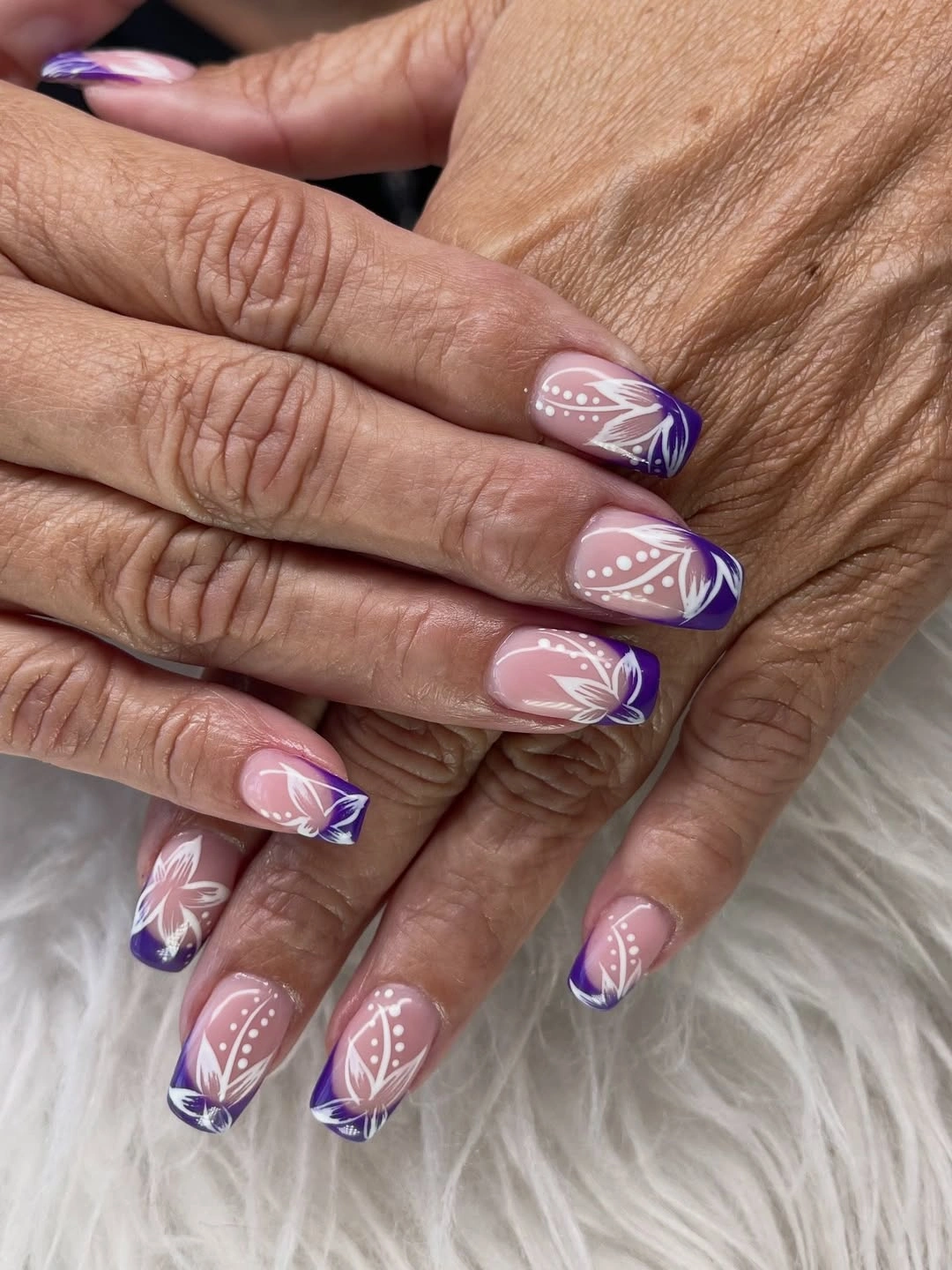 Sheer pink square nails with blue tips and white floral lines